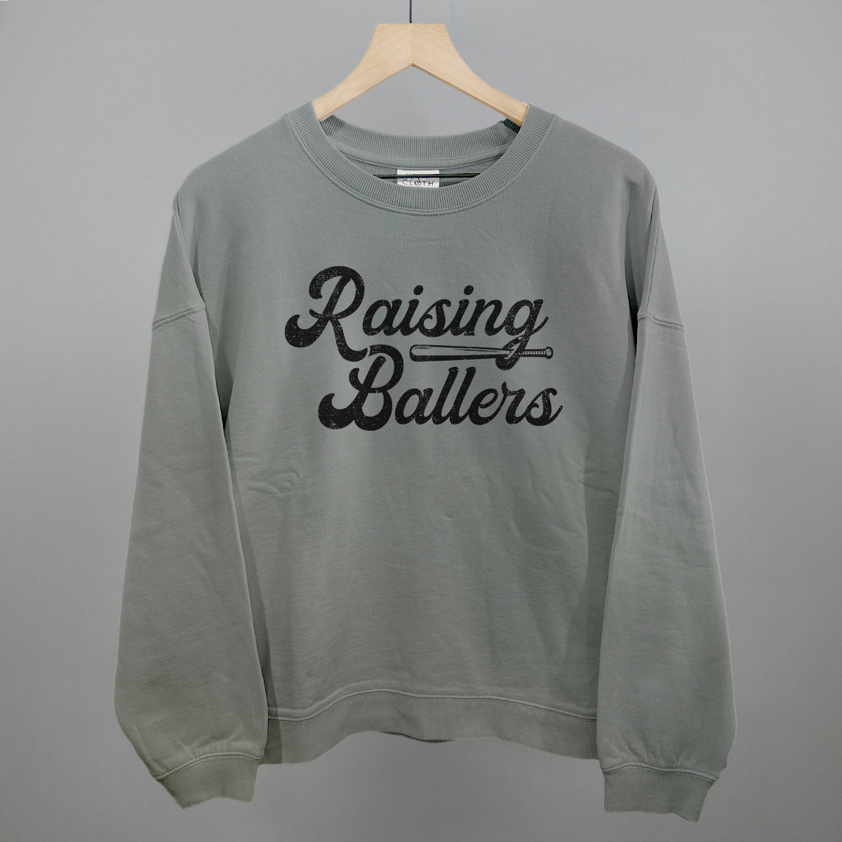 Gray sweatshirt with 'Raising Ballers' text on a gray background
