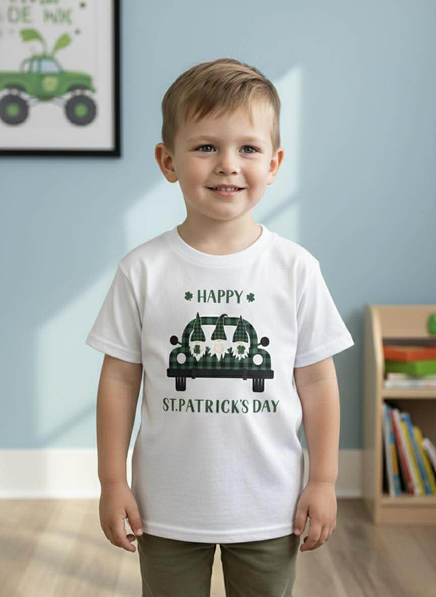 Child wearing a white t-shirt with a St. Patrick's Day design in a room with books and a toy car.